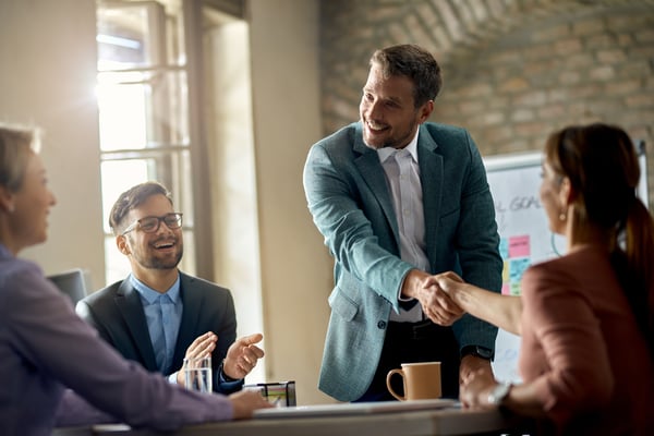 happy-businessmen-greeting-his-colleagues-meeting-shaking-hands-with-one-them-office